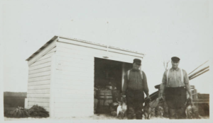 Two of the four Caines brothers in Bernard Baruch's employ, Sawney and Hucks, stand near a shed at Hobcaw's Clambank Landing as they prepare to clean ducks from the day's kill. c. 1919